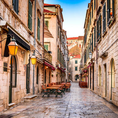 Smalle straat met stenen gebouwen en terrassen in de oude stad van Dubrovnik tijdens een 22-35ers reis Balkan.