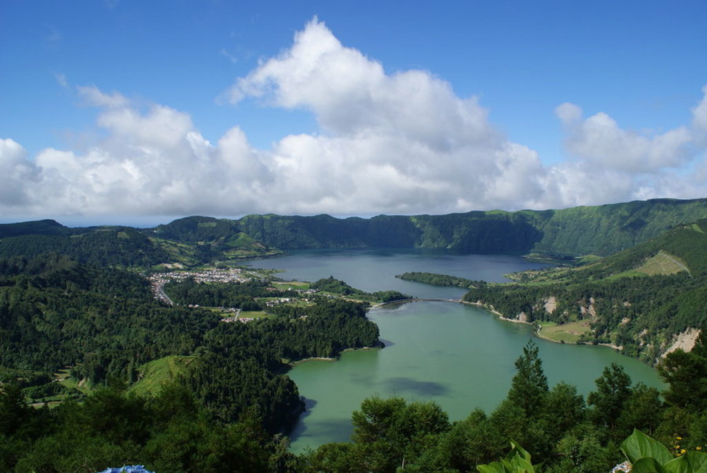 Uitzicht op het kratermeer Sete Cidades op São Miguel, Azoren, omringd door groene heuvels en wolkenlucht.