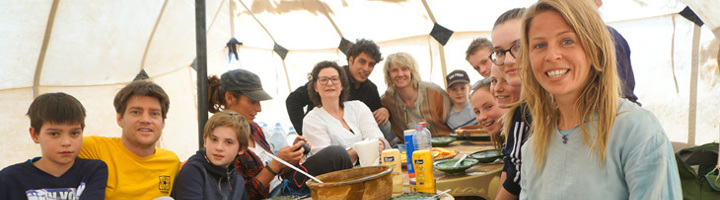 Groep reizigers eet samen in een tentenkamp in de Sahara woestijn.