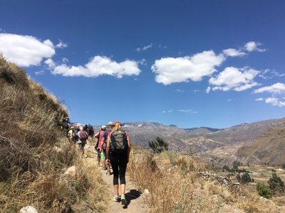 Wandelaars op bergpad met uitzicht over de Andesvallei in Peru tijdens de Route Peru-reis.