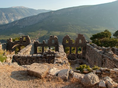 Ruïnes van een oude stenen nederzetting met uitzicht op de bergen langs de Turquoise Kust in Turkije.