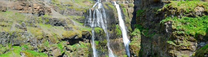 Waterval Glymur in IJsland tussen steile rotswanden en groene hellingen.