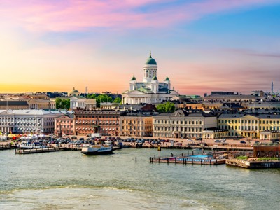 Skyline van Helsinki met de witte Domkerk aan de haven bij zonsondergang.