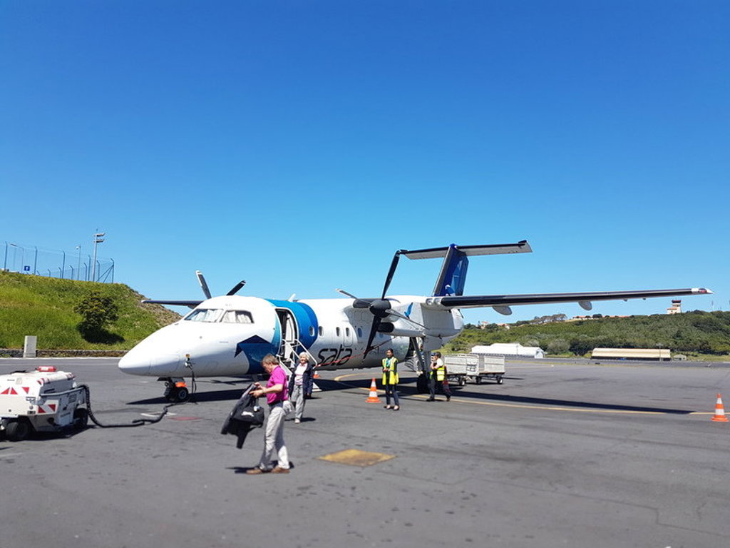 Passagiers stappen uit een SATA-propellervliegtuig op de Azoren tijdens familiereis Azoren.