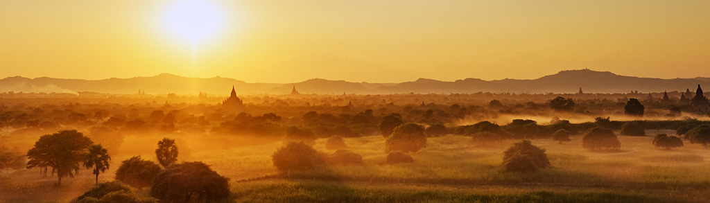 Zonsopkomst boven de tempelvlakte van Bagan in Myanmar, met mist en pagodes in de verte.