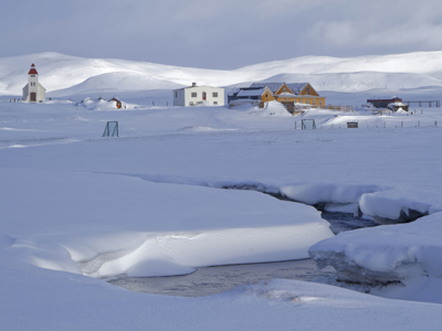 Sneeuwlandschap met kerk en boerderijen in Noord-IJsland langs de Route Noord-IJsland.