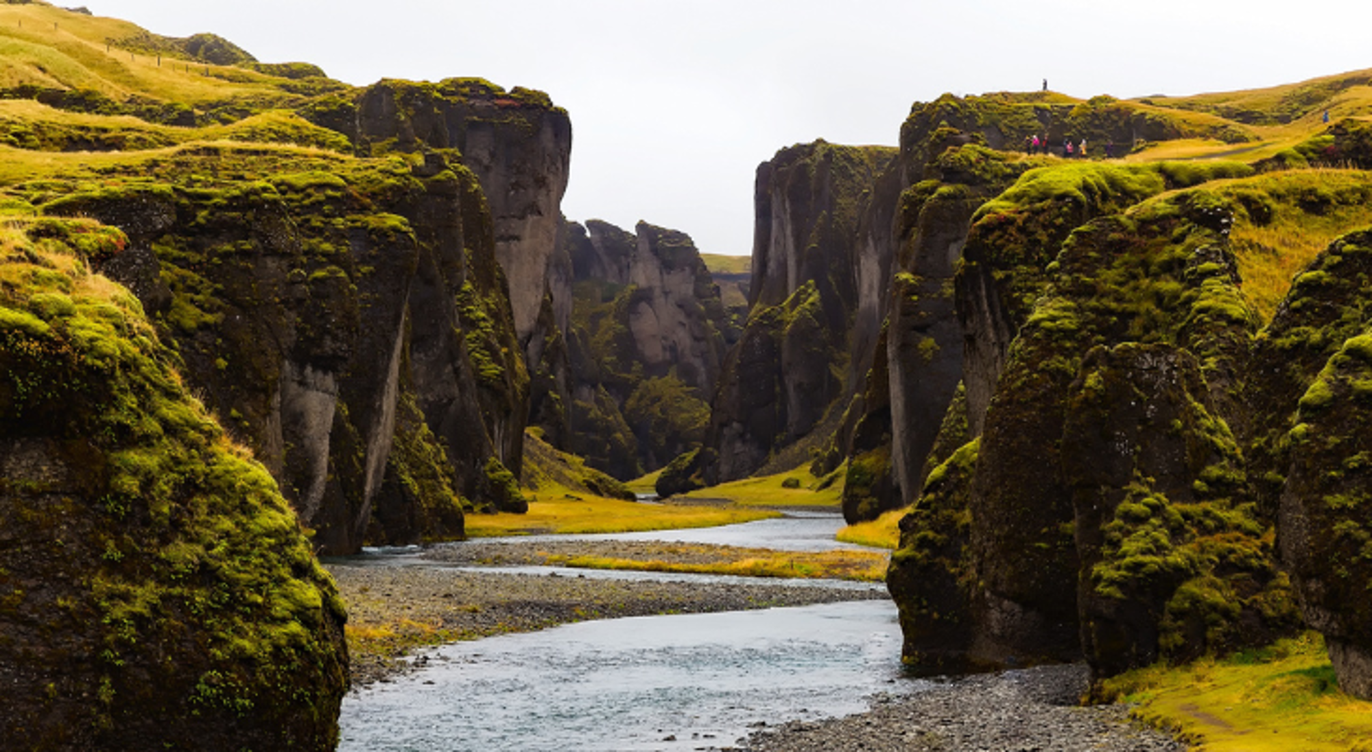 Pingvellir in IJsland Groene kloof met steile rotswanden en een rivier die door de vallei stroomt.