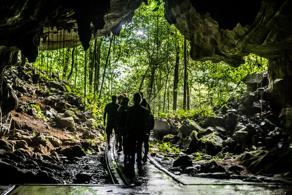 Gezin wandelt door een grot met jungle-uitzicht in Maleisisch Borneo tijdens familiereis.