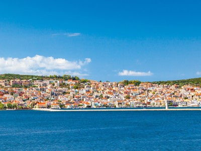 Kustplaats op Samos met witgekalkte huizen en rode daken aan zee, route Griekenland.