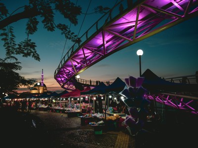 Avondmarkt onder de paars verlichte Darul Hana Bridge in Kuching, Sarawak, Maleisisch Borneo.