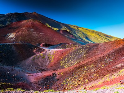 Wandelaars op de kleurrijke lavavelden en kraters van de Etna op Sicilië.