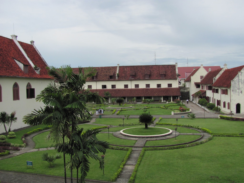Binnenplaats van Fort Rotterdam in Makassar, Sulawesi, met symmetrische tuinen en witte gebouwen met rode daken.