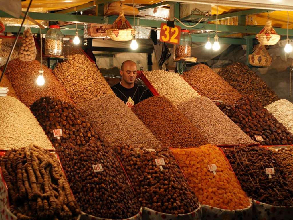 Marktkraam in Marokko met grote hopen noten en gedroogd fruit tijdens groepsrondreis Marokko Hoogtepunten.