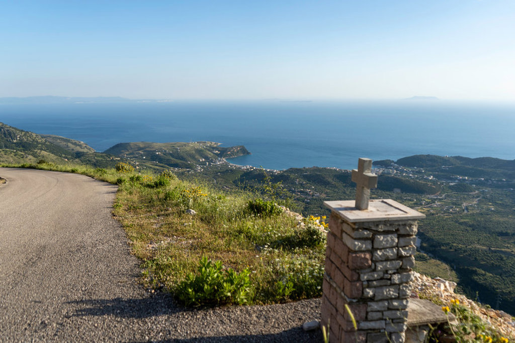 Uitzichtpunt tijdens wandelvakantie Albanië met kronkelweg en panorama over de Albanese Rivièra en zee.