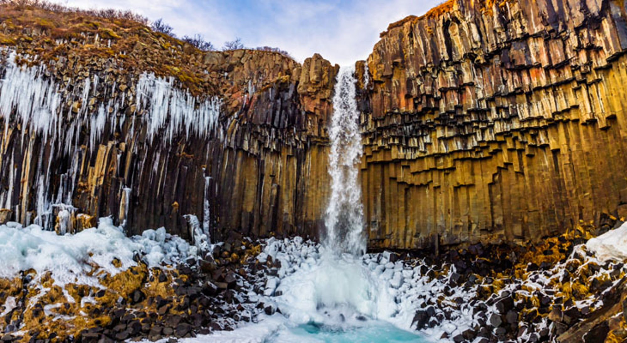 Waterval Skaftafell Nationaal Park Waterval bij basaltkolommen met ijs en sneeuw in IJsland.