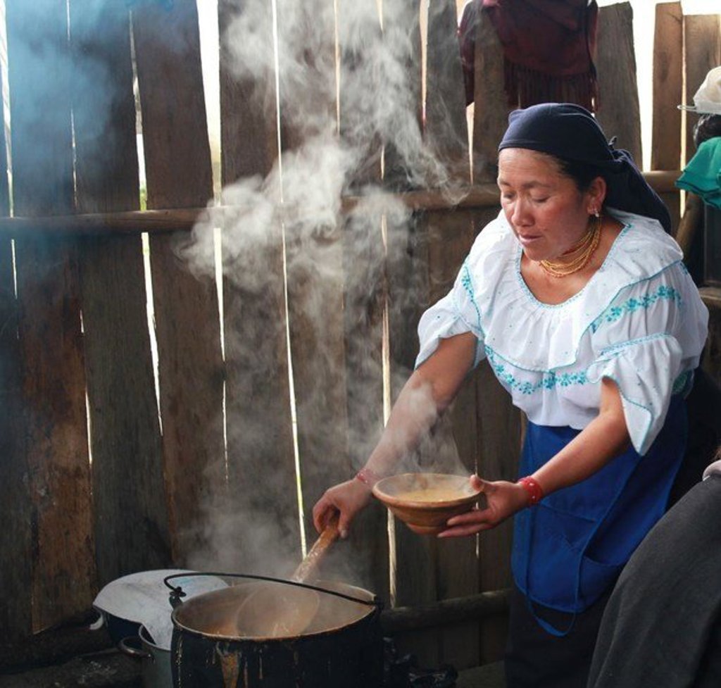 Toeriste kijkt uit over een groen berglandschap in Ecuador tijdens een groepsrondreis.