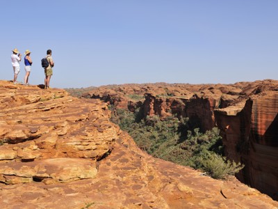Uitzicht over de Kings Canyon in Australië, met reizigers op een rotsplateau.