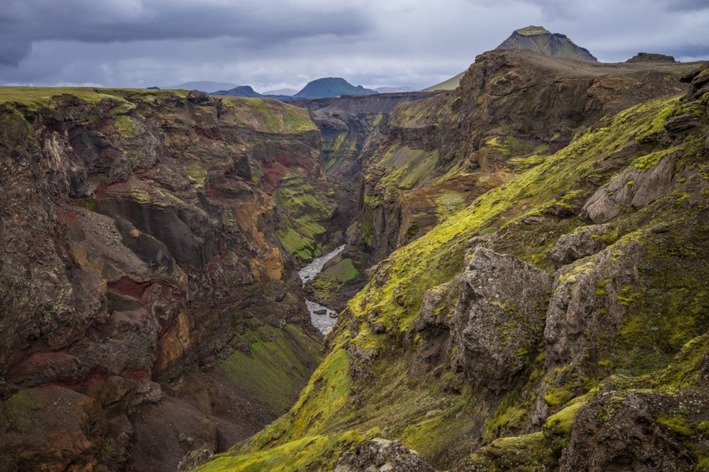 Groene kloof met rivier en vulkanische rotswanden langs de Laugavegur Trail in IJsland.