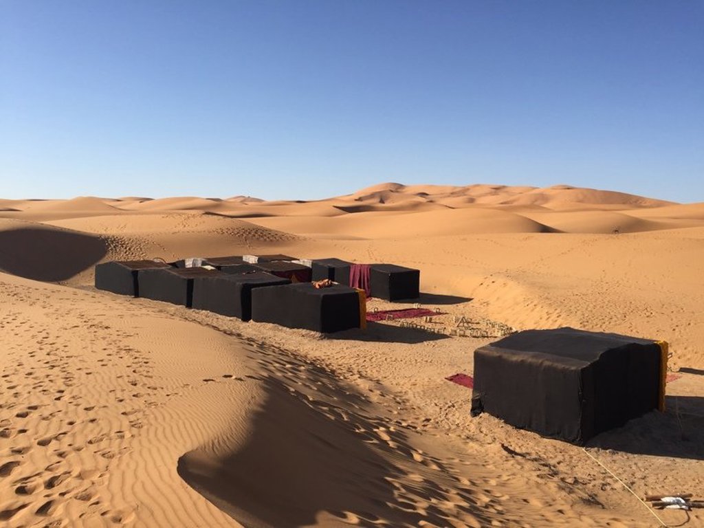 Woestijnkamp met tenten tussen de zandduinen tijdens groepsrondreis Marokko Hoogtepunten.