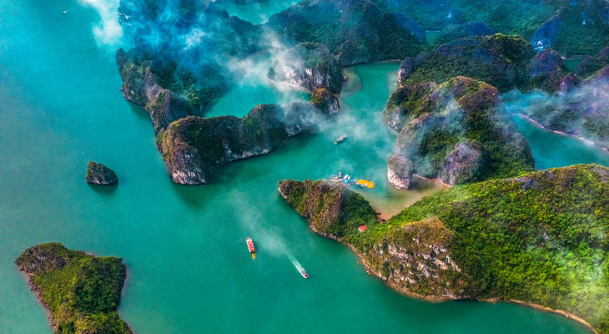 Luchtfoto Ha Long Bay Ha Long Bay in Vietnam met kalkstenen eilanden, turquoise water en boten tussen de rotsen.