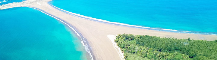 Punta Mala met zandtong tussen helderblauwe oceaan en groene kuststrook in Costa Rica.