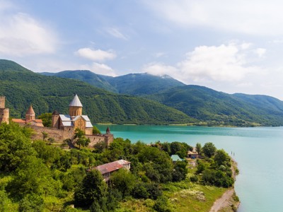 Ananuri-fort en kerk aan het Jinvali-reservoir in Georgië, met groene bergen op de achtergrond.