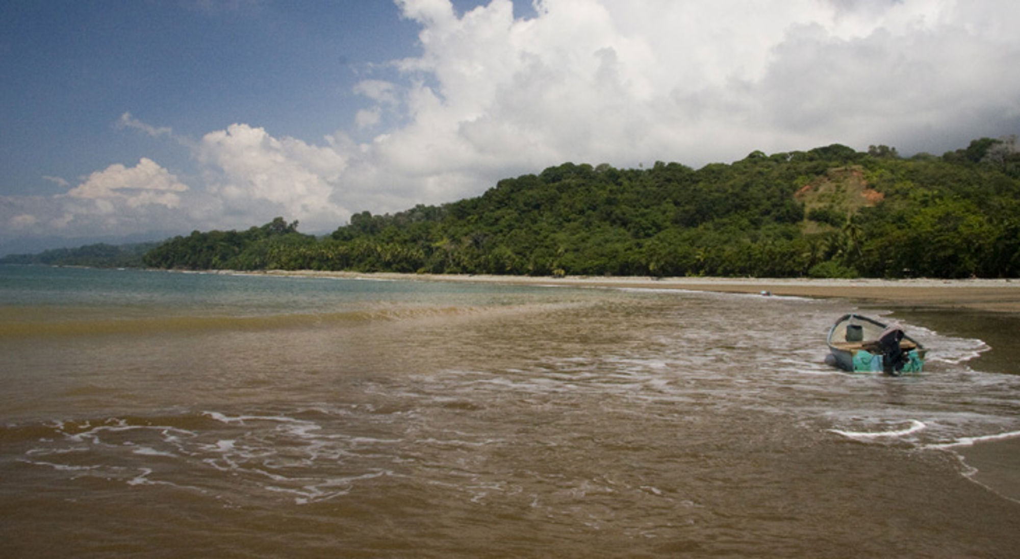 Marino Ballena NP Bootje op een rustig strand met tropisch regenwoud aan de kust in Costa Rica.