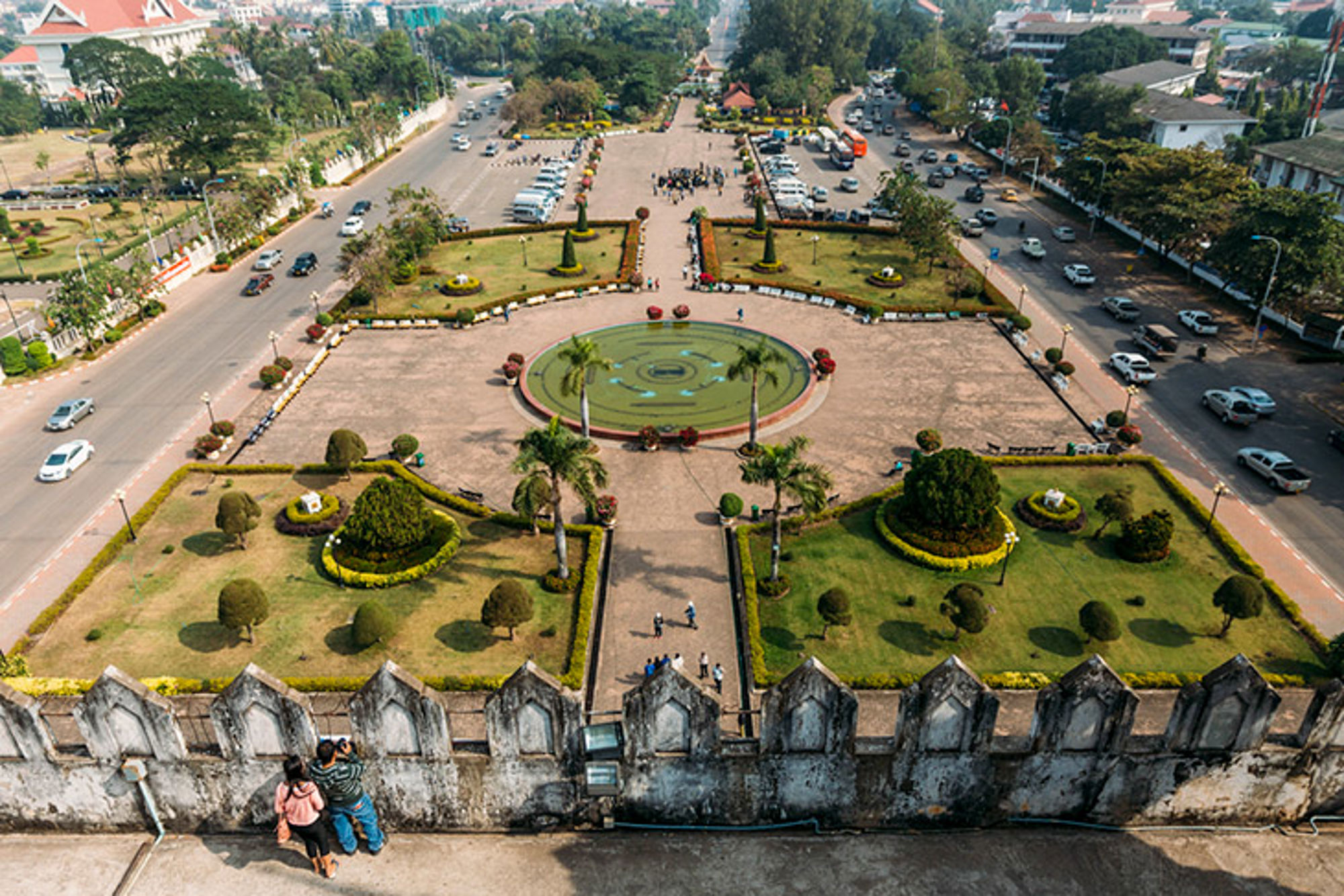 Sfeervol Laos Uitzicht op Patuxai-park in Vientiane met rotonde, tuinen en druk verkeer rondom.