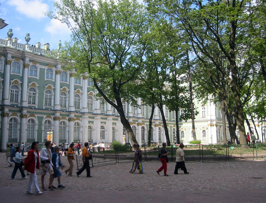 Bezoekers wandelen langs het Winterpaleis in Sint-Petersburg tijdens een groepsrondreis Rusland.