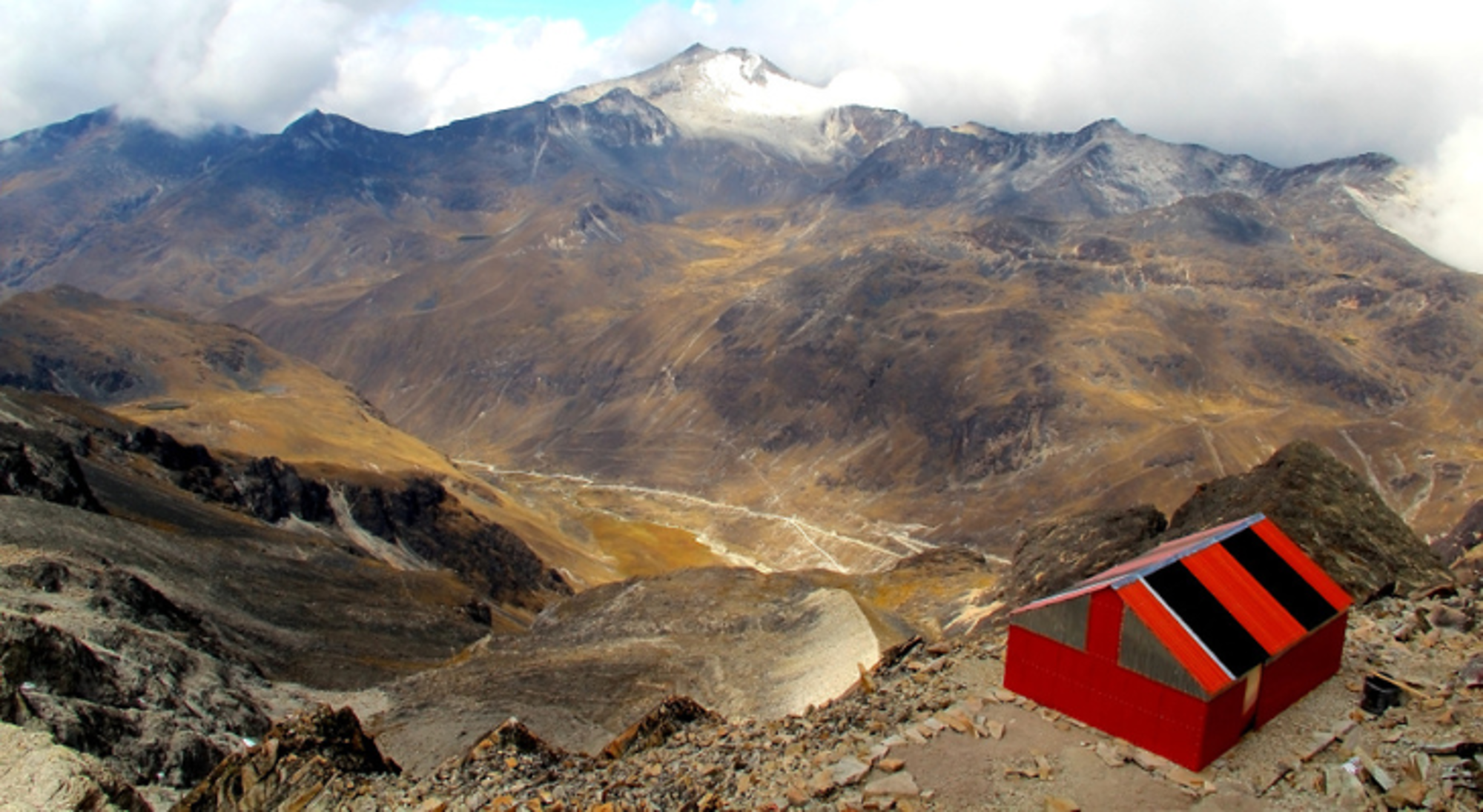 Huayna Potosi Uitzicht op het Andesgebergte in Bolivia met een rood bergschuilhutje op de voorgrond.