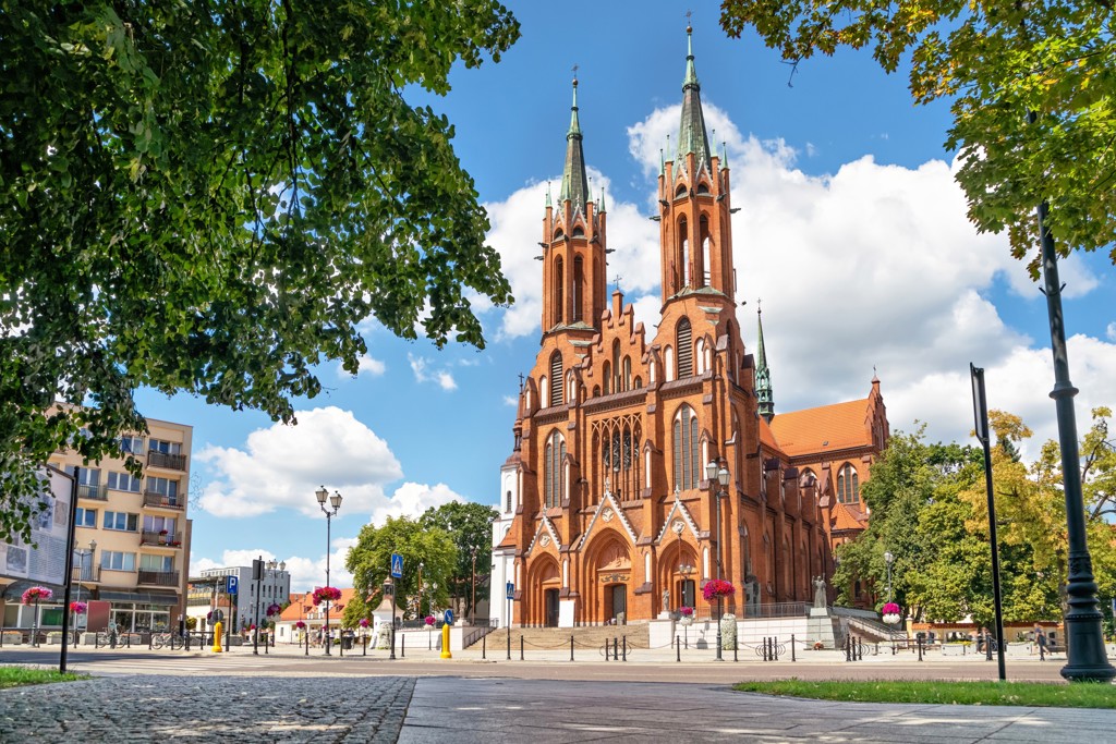 Neogotische kathedraal met twee torens aan een plein in Polen tijdens een groepsrondreis.