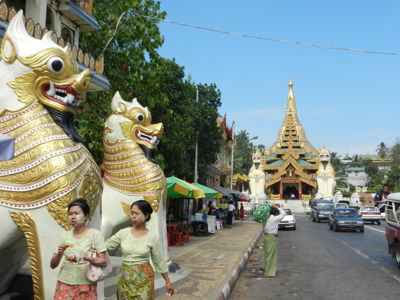 Straatbeeld in Yangon met leeuwbeelden bij de ingang van de Shwedagon Pagode, Myanmar.