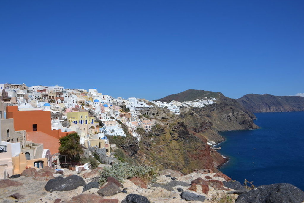 Witte huizen van Santorini op de kliffen met uitzicht op de blauwe Egeïsche Zee tijdens wandelvakantie Griekenland.