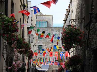 Sfeervolle straat in Galway met kleurrijke vlaggetjes en bloembakken tijdens de route Verenigd Koninkrijk & Ierland, 21 dagen.