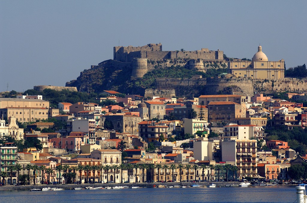 Uitzicht op Milazzo op Sicilië met kasteel en koepelkerk boven de stad aan zee.