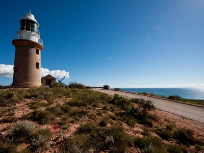 Vuurtoren bij de kust van West-Australië met uitzicht op zee en blauwe lucht.