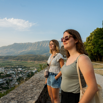Twee reizigers bij een uitzichtpunt met panorama over de vallei en bergen tijdens de familiereis Albanië, Kosovo & Noord-Macedonië.