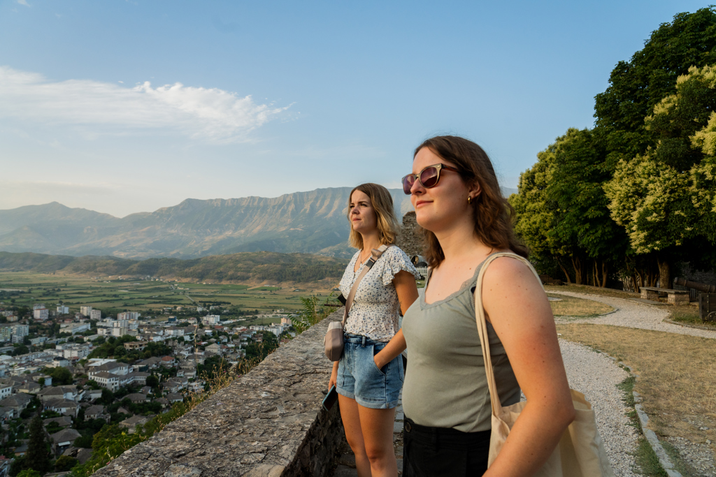 Twee reizigers bij een uitzichtpunt met panorama over de vallei en bergen tijdens de familiereis Albanië, Kosovo & Noord-Macedonië.