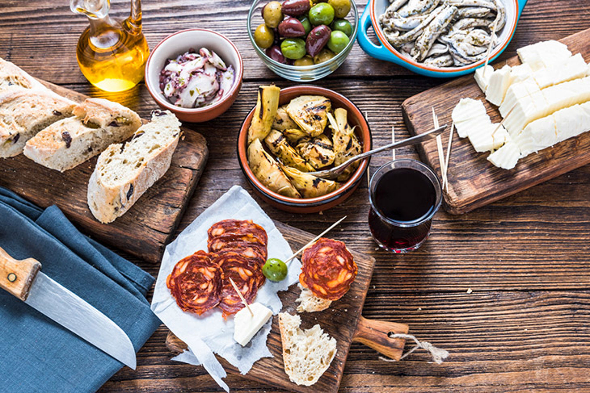 Tapas eten in Italië Tapasplank met brood, olijven, kaas, chorizo, gegrilde groenten en een glas rode wijn.