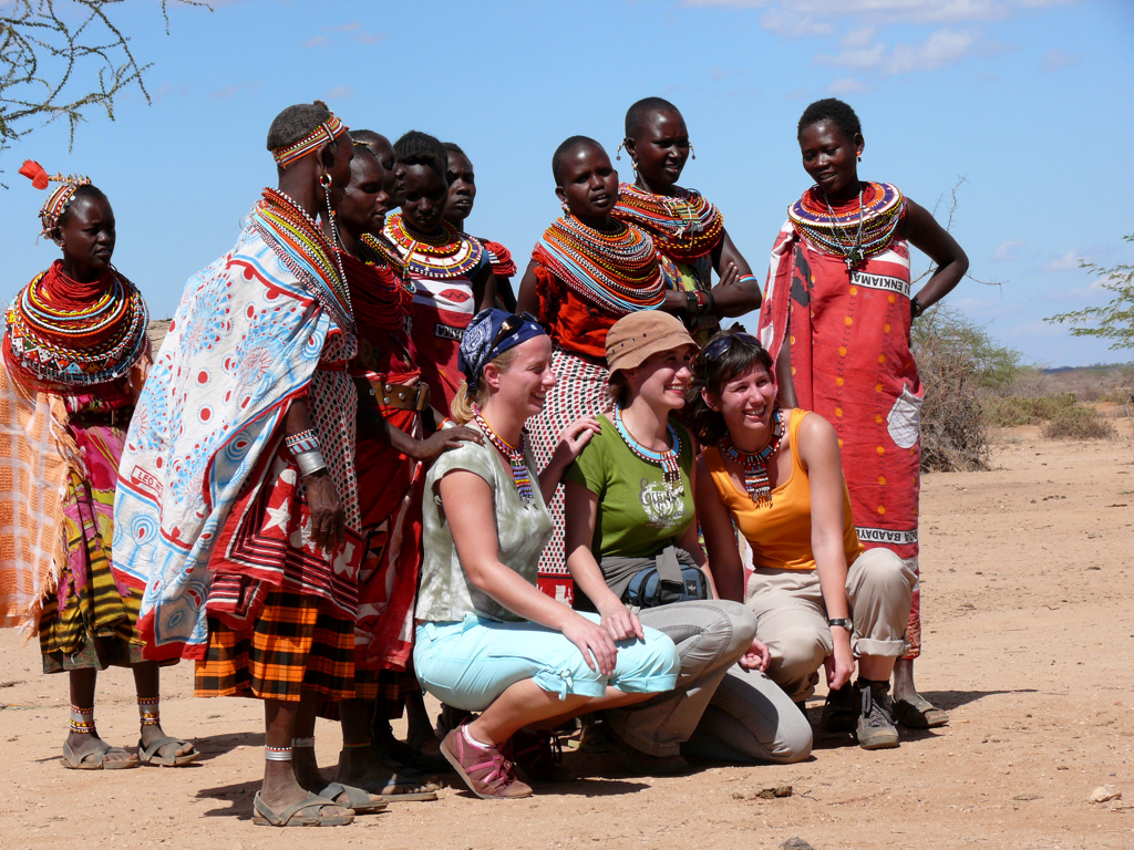 Reizigers poseren met Samburu-vrouwen in traditionele kleding tijdens familiereis in Kenia, Tanzania en Zanzibar.