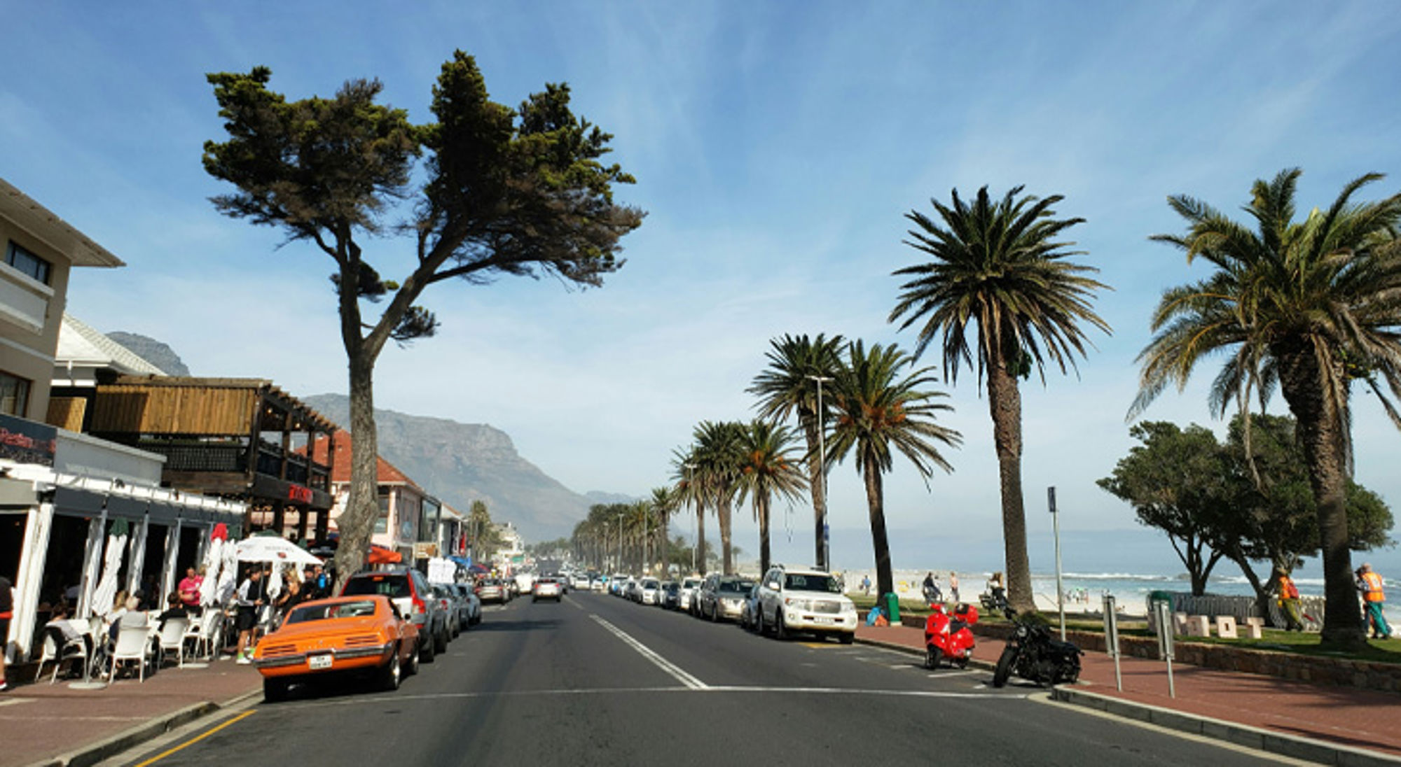 Straat in Camps Bay Palmboomrijke boulevard langs het strand in Kaapstad, met uitzicht op de Tafelberg.