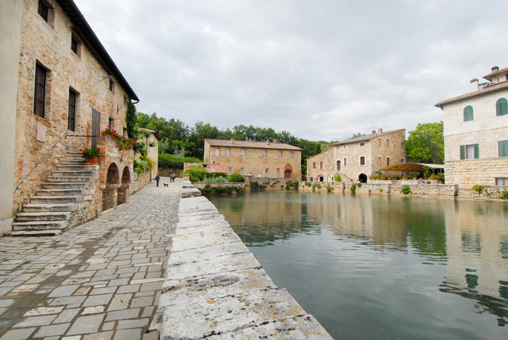 Middeleeuws dorp Bagno Vignoni in Toscane met stenen huizen rond het thermale waterbassin.