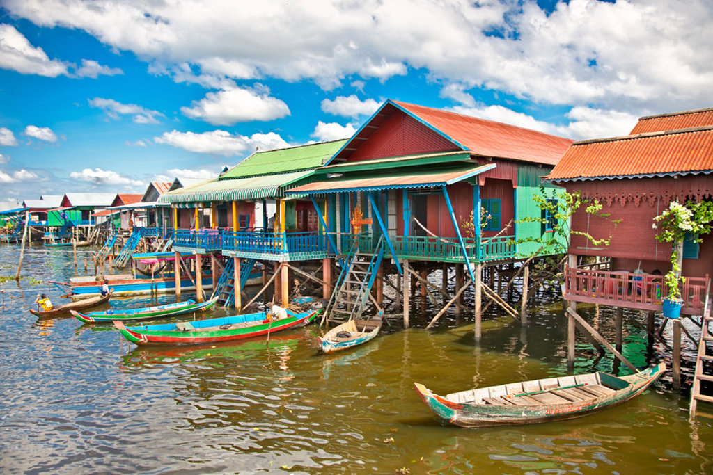 Kleurrijke paalwoningen en houten boten op het Tonlé Sap-meer in Cambodja tijdens een groepsrondreis Laos & Cambodja.