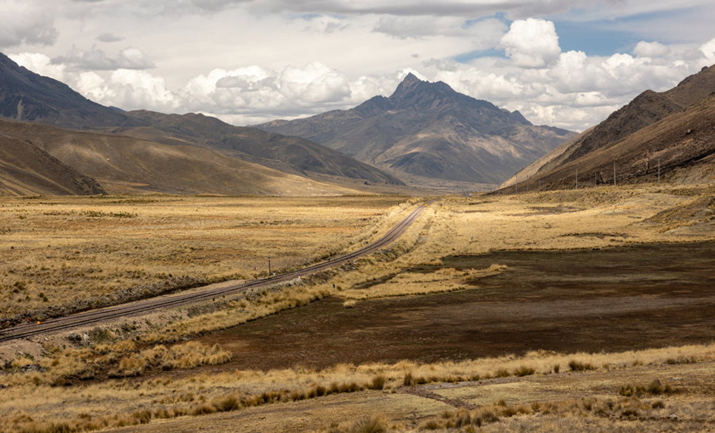 Berglandschap in Peru met spoorlijn door de uitgestrekte hoogvlakte, tijdens groepsrondreis Peru.