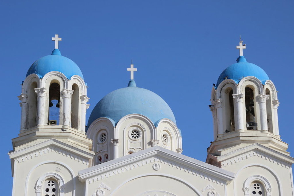 Witte Grieks-orthodoxe kerk met blauwe koepels op Evia, Griekenland.