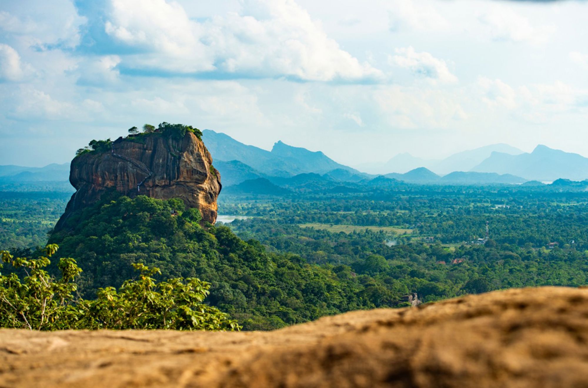 Uitzicht op de Sigiriya-rots met groene jungle en bergen in de verte, Sri Lanka.
