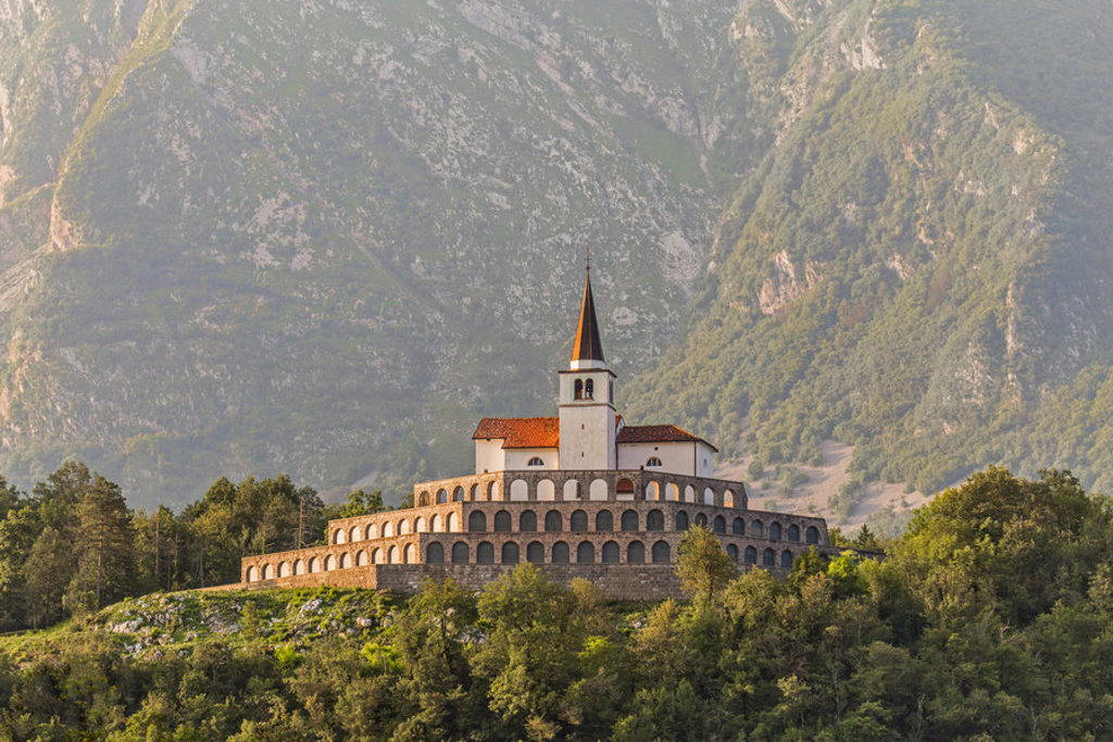 Kerk van het Heilig Hart van Jezus in Bovec, Slovenië, met bergen op de achtergrond.