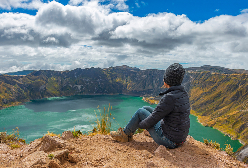 Reiziger kijkt uit over het Quilotoa-kratermeer in Ecuador tijdens een groepsrondreis, met optioneel Galapagos.