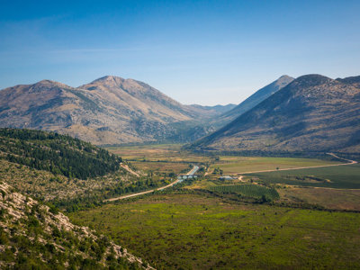 Berglandschap met groene vallei en slingerende weg langs de route van de fietsvakantie Kroatië en de Balkan.