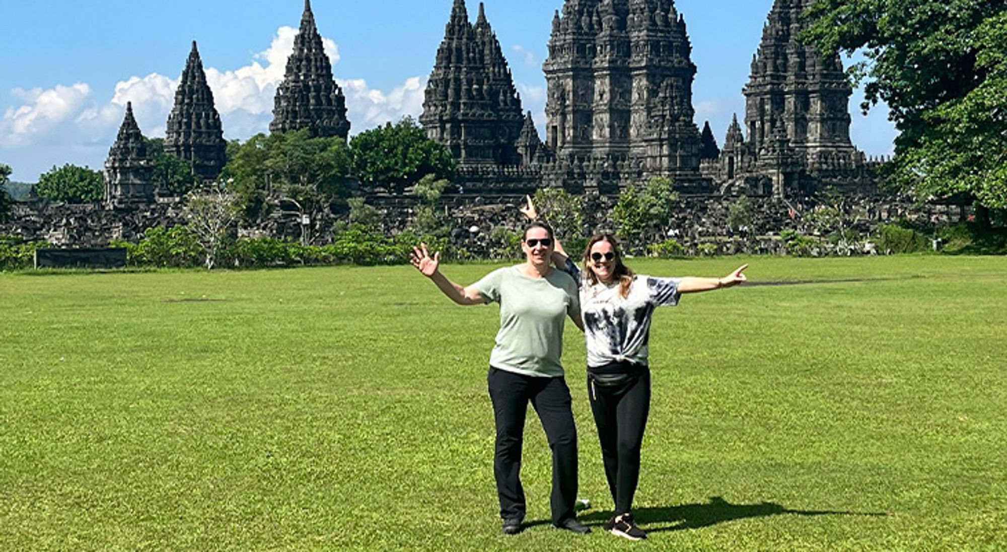 Sylvia en Lisanne in Indonesië Twee reizigers poseren op het gras voor de Prambanan-tempels in Yogyakarta, Indonesië.